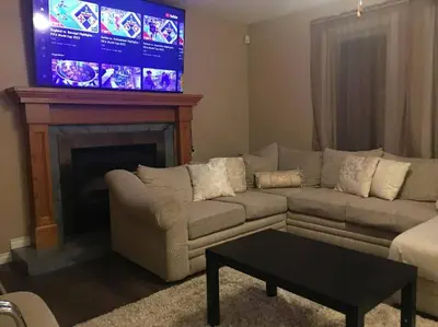 a living room with a couch and a tv at Renovated 4 bedrooms 20 sleeps Shopping Center in Edmonton