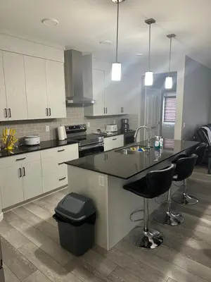 a kitchen with a counter and stools in it at 3 Bedroom House in NW Calgary in Calgary