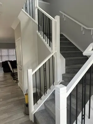 a white staircase with black railings in a house at 3 Bedroom House in NW Calgary in Calgary