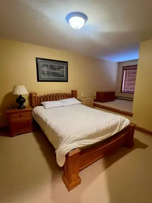 a bedroom with a bed and a lamp and a window at Townhouse, Ski in Ski out in Big White