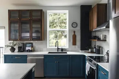 a kitchen with blue cabinets and a sink and a window at Lokis Loft and Cellar at the 1896 Building in Kaslo