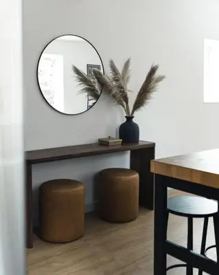 a mirror in a room with a table and stools at The Crow's Nest at the 1896 Building in Kaslo