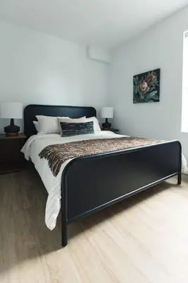 a bedroom with a bed with a black frame at The Crow's Nest at the 1896 Building in Kaslo