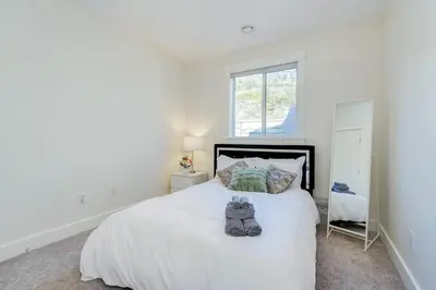 a bedroom with a white bed with two stuffed animals on it at Elegant Home In Victoria,BC in Langford