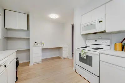 a kitchen with white appliances and white cabinets at Stunning House In Victoria, BC in Victoria