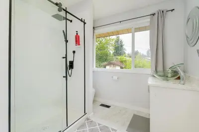 a white bathroom with a shower and a sink at Stunning House In Victoria, BC in Victoria