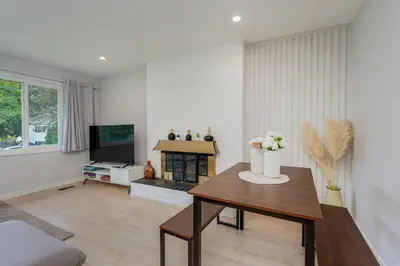 a living room with a table and a tv at Stunning House In Victoria, BC in Victoria
