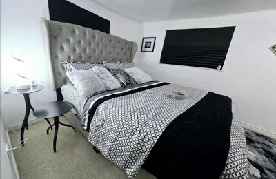 a black and white bedroom with a bed and a table at Private Cozy 1Br Basement Suite Perfect for Couple! With Date Bar for 2! Self Check-in, Private Parking in Burnaby