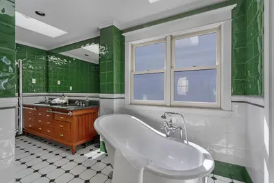 a green and white bathroom with a tub and a sink at The Vancouver Heritage Home - Mount Pleasant in Vancouver