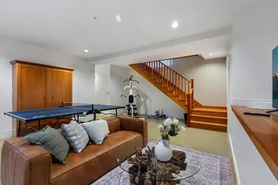 a living room with a couch with a ping pong table at The Vancouver Heritage Home - Mount Pleasant in Vancouver
