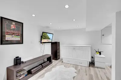 a living room with white walls and a tv at Comfortable 2-Bed Suite Near UBC in Vancouver