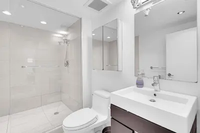 a white bathroom with a toilet and a sink at Comfortable 2-Bed Suite Near UBC in Vancouver