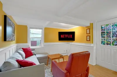 a living room with a couch and a tv on the wall at Artsy Private Guest Suite with Outdoor Saloon in Vancouver