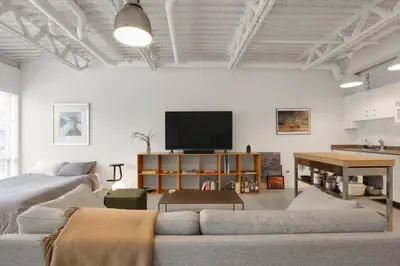 a living room with a couch and a flat screen tv at Modern and Specious Condo right off Main St in Vancouver
