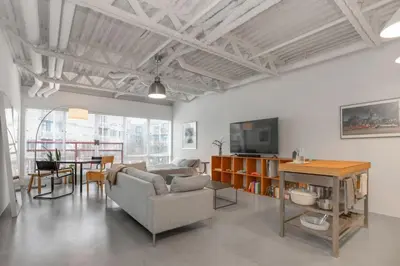 a living room with a couch and a tv and a table at Modern and Specious Condo right off Main St in Vancouver