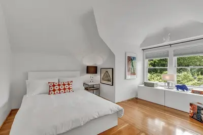 a white bedroom with a large bed and a window at The Queen Elizabeth Park Home in Vancouver