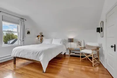 a bedroom with a bed and a chair and a window at The Queen Elizabeth Park Home in Vancouver