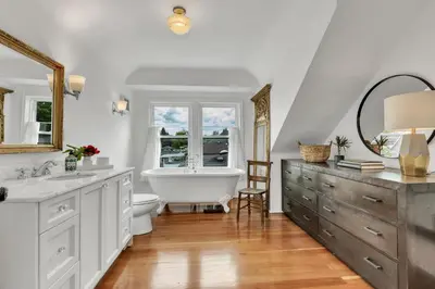 a bathroom with a tub and a toilet and a sink at The Queen Elizabeth Park Home in Vancouver