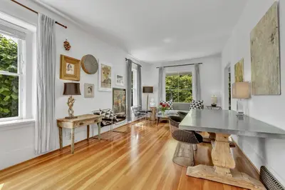 a living room with white walls and a wooden floor at The Queen Elizabeth Park Home in Vancouver