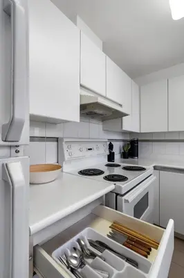 a kitchen with white appliances and white cabinets at Central Downtown Highrise Condo in Vancouver