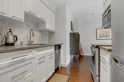 a kitchen with white cabinets and a sink at Modern Kitsilano 1 bedroom steps from the Beach in Vancouver