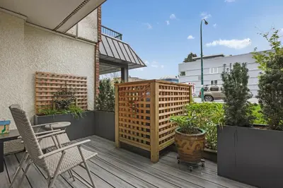 a patio with a wooden deck with a table and chairs at Modern Kitsilano 1 bedroom steps from the Beach in Vancouver