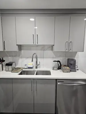 a kitchen with white cabinets and a sink at Contemporary Two Bedroom Basement Suite in Edmonton