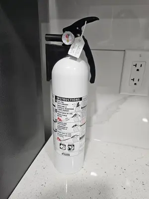 a white fire extinguisher is attached to a wall at Contemporary Two Bedroom Basement Suite in Edmonton