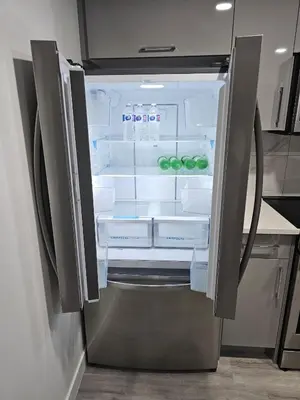 an open refrigerator with its door open in a kitchen at Contemporary Two Bedroom Basement Suite in Edmonton