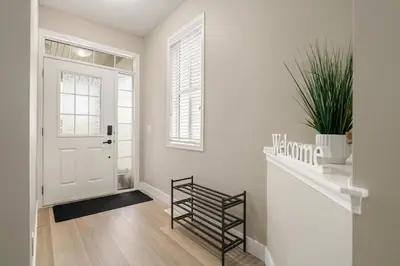 a white hallway with a staircase and a white door at A beautiful home in Airdrie in Airdrie