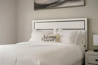 a white bed with a pillow on top of it at A beautiful home in Airdrie in Airdrie