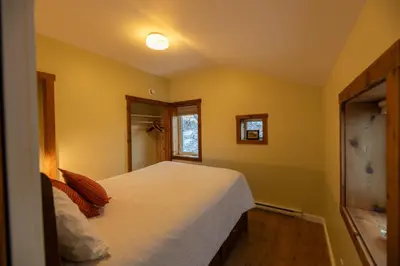 a bedroom with a white bed and a window at Located in Downtown Whitehorse - Treehouse in Whitehorse