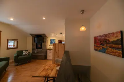 a living room with a green couch and a kitchen at Located in Downtown Whitehorse - Treehouse in Whitehorse