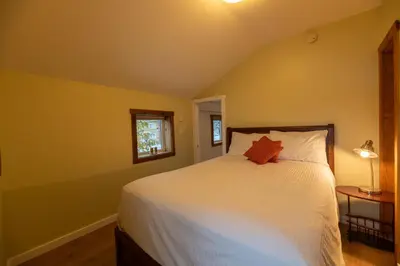 a bedroom with a white bed and a window at Located in Downtown Whitehorse - Treehouse in Whitehorse