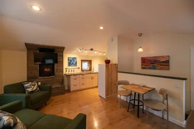 a living room with a couch and a table at Located in Downtown Whitehorse - Treehouse in Whitehorse
