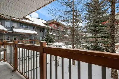 a balcony of a house with snow on the ground at Modern Cabin Vibes with pool at The Lodges in Canmore