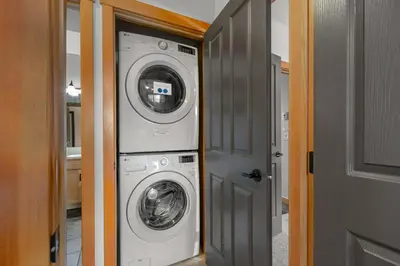 a washer and dryer in a hallway of a house at Modern Cabin Vibes with pool at The Lodges in Canmore