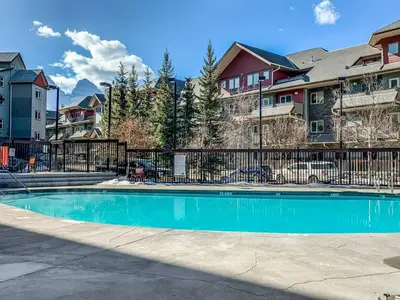 a swimming pool in a apartment complex with houses at Modern Cabin Vibes with pool at The Lodges in Canmore
