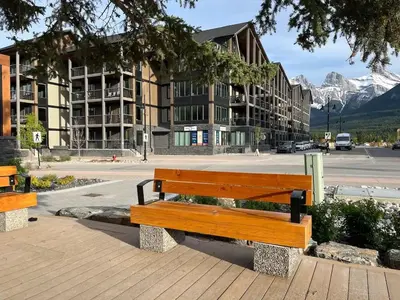 a wooden bench sitting in front of a building at New 1Bd Luxe King Suite with Superb Mtn View in Canmore