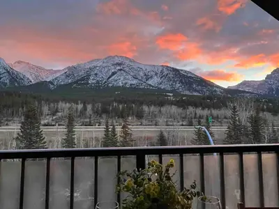 a view of snow covered mountains from a balcony at Stunning Silver Creek 1Br Mtn view penthouse in Canmore