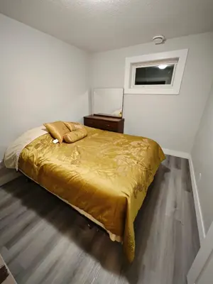 a bedroom with a gold bed with a window at Chamber Inn in Edmonton