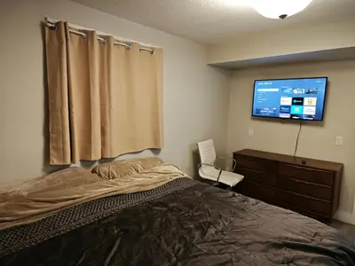 a bedroom with a bed and a flat screen tv at Chamber Inn in Edmonton