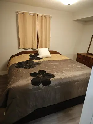 a bedroom with a bed with a flower on it at Chamber Inn in Edmonton