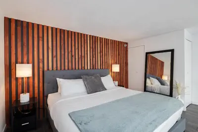a bedroom with a large bed and a wooden wall at Loft in Entertainment District with FREE underground Parking in Vancouver