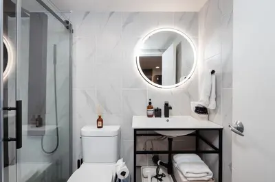 a bathroom with a toilet and a sink and a mirror at Loft in Entertainment District with FREE underground Parking in Vancouver