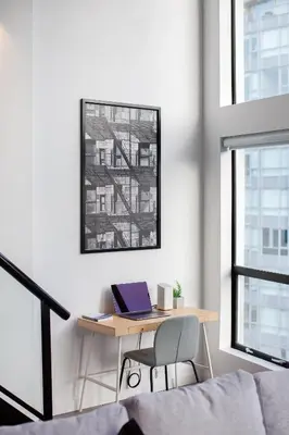 a desk with a laptop on it in a room with windows at Loft in Entertainment District with FREE underground Parking in Vancouver