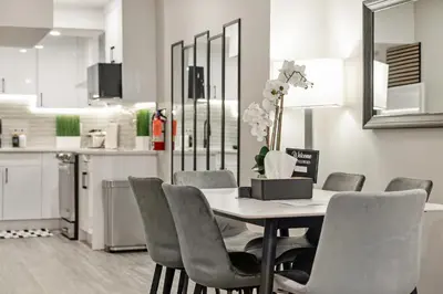 a dining room with a table and chairs and a kitchen at Luxury Living Entire Suite-Private in Calgary