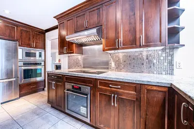 a kitchen with wooden cabinets and stainless steel appliances at The Ester House in Vancouver