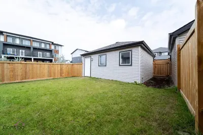 a backyard with a tiny house and a fence at The Nest, 3BR, AC, Near YEG Airport, King Bed! in Edmonton