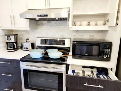 a kitchen with a stove top oven and a microwave at Luxury Cozy Basement Suite in Leduc